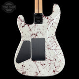 White electric guitar with red splatter design on a black background, featuring the Tone Shop logo.