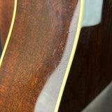 Close-up of a glossy dark brown wooden surface with visible scratches and scuffs, bordered by a pale yellow edge.