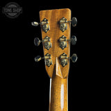 Close-up of a guitar headstock with tuning pegs on a black background, featuring the Tone Shop logo.