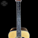 Close-up of an acoustic guitar's soundhole and neck on a black background with 'Tone Shop' logo.