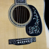 Close-up of an acoustic guitar with decorative inlay on the soundhole and bridge.