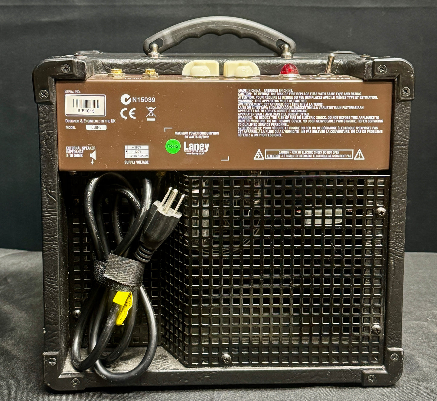 Guitar amplifier with power cord on a dark background