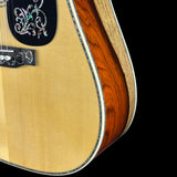 Close-up of a guitar with a decorative pickguard on a black background