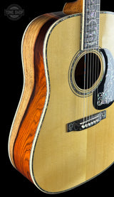 Acoustic guitar with a visible brand logo on a black background