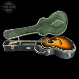 Acoustic guitar in a hard-shell case with 'Tone Shop' logo.