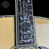 Close-up of a guitar's fretboard with decorative inlays on a black background, featuring the Tone Shop logo.