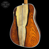Close-up of a guitar's wooden back and sides with 'Tone Shop' logo.