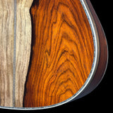 Close-up of a wooden acoustic guitar body with a focus on the grain and texture.