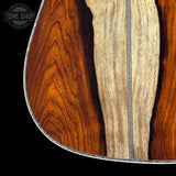 Close-up of a guitar's wood finish with a visible brand logo in the corner.