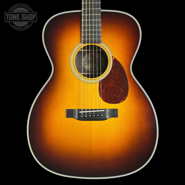 Acoustic guitar with a sunburst finish on a black background, featuring the Tone Shop logo.
