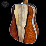 Close-up of a guitar's wooden body with a visible brand logo in the corner.