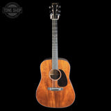 Acoustic guitar with a visible brand logo on a black background
