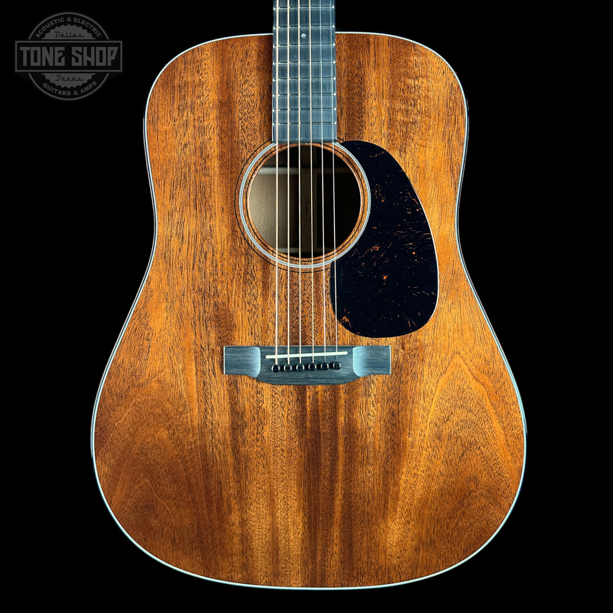 Acoustic guitar with a visible brand logo on a black background