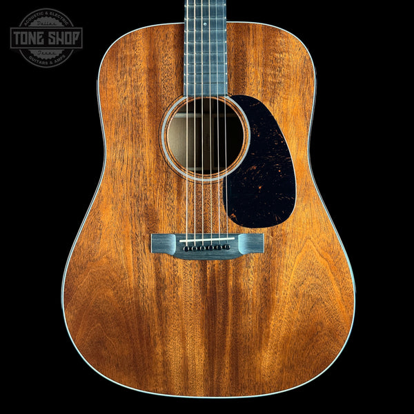 Acoustic guitar with a visible brand logo on a black background