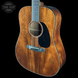 Acoustic guitar with a visible brand logo on a black background