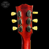 Close-up of a red guitar headstock with yellow tuning pegs on a black background, featuring 'Tone Shop' branding.
