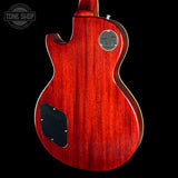 Red electric guitar body with a visible brand logo on a black background