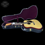 Acoustic guitar in an open case with 'Tone Shop' branding.