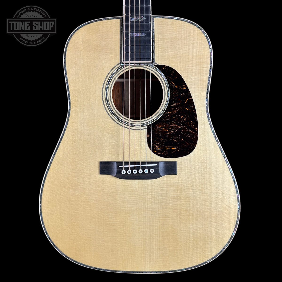 Acoustic guitar with a visible brand logo on a black background