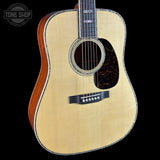 Acoustic guitar with a visible brand logo on a black background