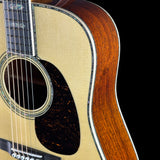 Close-up of a acoustic guitar with a wooden body and neck on a black background