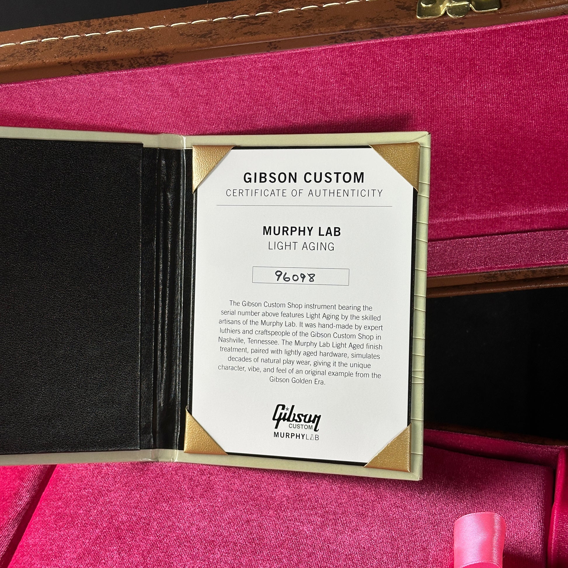 Gibson Custom Certificate of Authenticity for a Murphy Lab guitar on a pink interior background