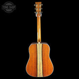 Back view of a wooden acoustic guitar with 'Tone Shop' logo in the corner.