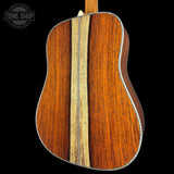 Close-up of a wooden acoustic guitar with a visible brand logo in the corner.