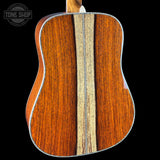 Close-up of a wooden acoustic guitar with a visible brand logo in the corner.