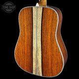 Close-up of a wooden acoustic guitar with a visible brand logo in the corner.