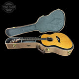 Acoustic guitar in an open case with 'Tone Shop' branding.