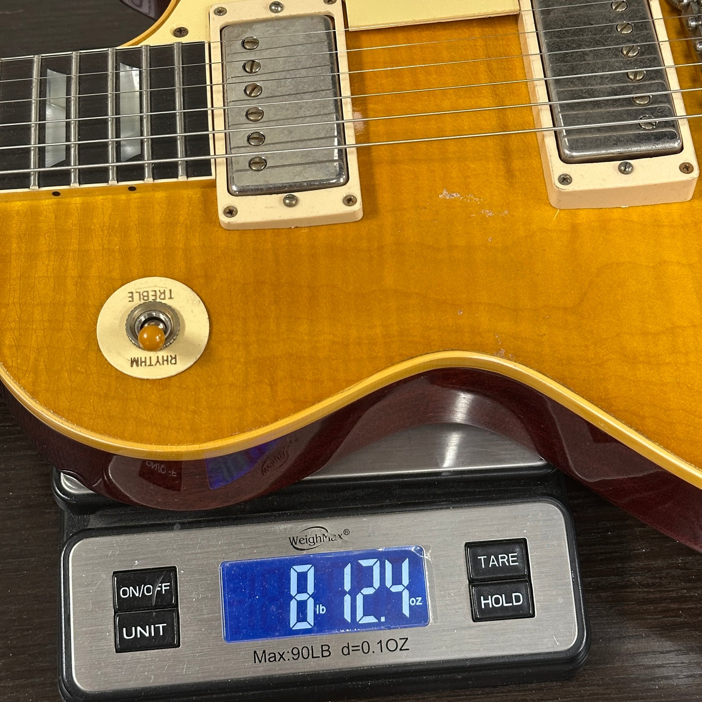 Electric guitar on a digital scale displaying weight