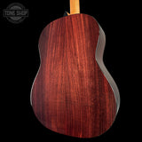 Close-up of a wooden acoustic guitar body with 'Tone Shop' logo in the corner.