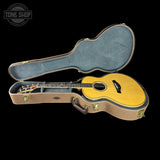 Acoustic guitar in a hard-shell case with 'Tone Shop' logo.