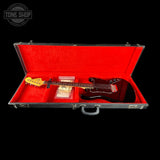 Guitar in a red-lined case with 'Tone Shop' logo.