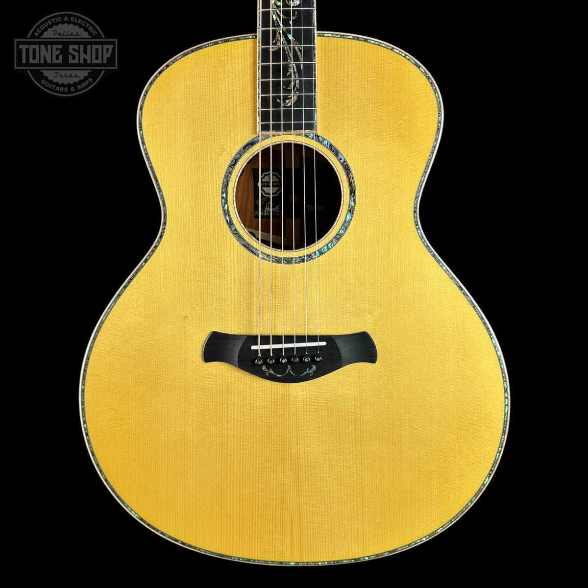 Acoustic guitar with a visible brand logo on a black background