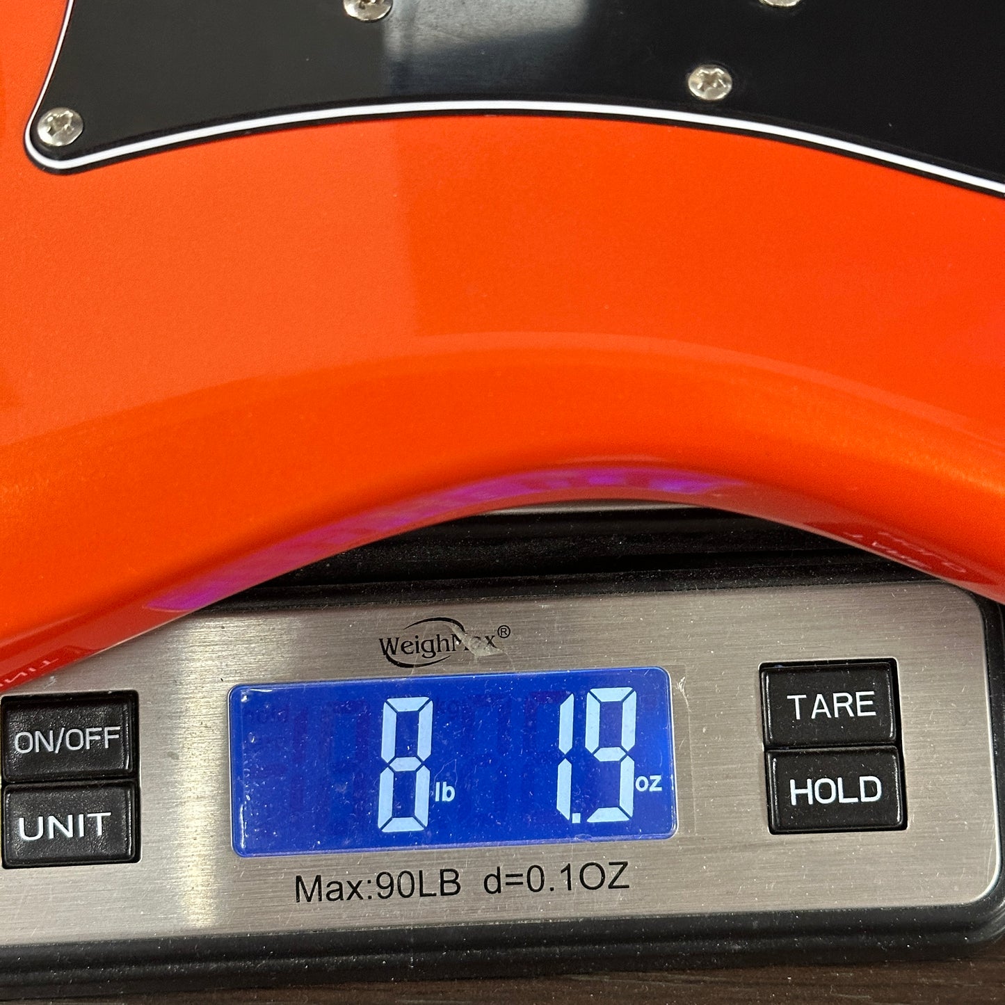 Used PRS NF3 Metallic Orange on a scale displaying weight.