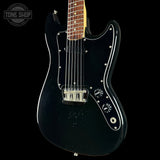 Black electric guitar with a visible brand logo on a black background