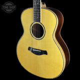 Acoustic guitar with a visible brand logo on a black background