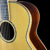 Close-up of an acoustic guitar's soundhole and neck on a black background