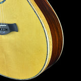 Close-up of a wooden acoustic guitar on a black background