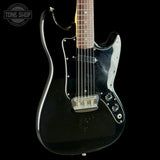 Black electric guitar with a visible brand logo on a black background