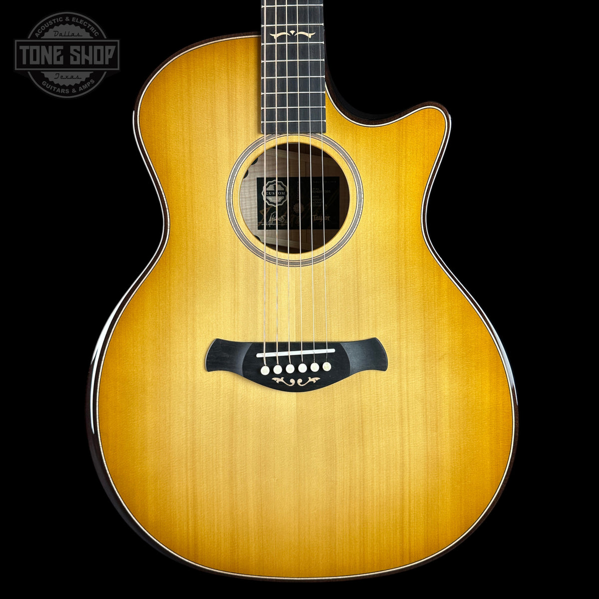Acoustic guitar with a visible brand logo on a black background