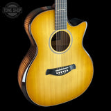 Acoustic guitar with a visible brand logo on a black background