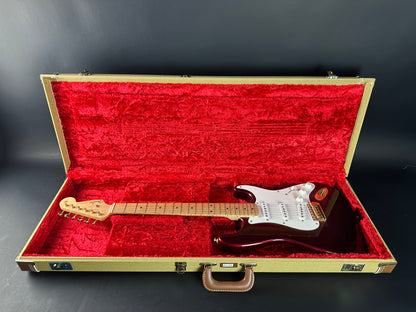 Electric guitar in an open case with red interior on a dark background