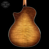 Back view of a wooden acoustic guitar with 'Tone Shop' logo in the corner.