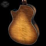 Close-up of a wooden acoustic guitar body with 'Tone Shop' logo.