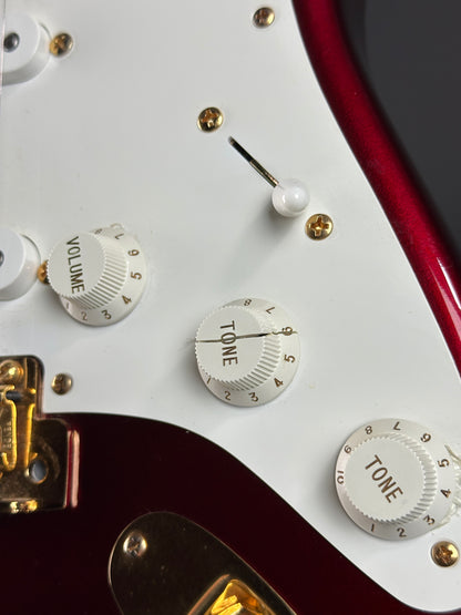 Close-up of a guitar's control knobs with 'TONE' and 'VOLUME' labels.