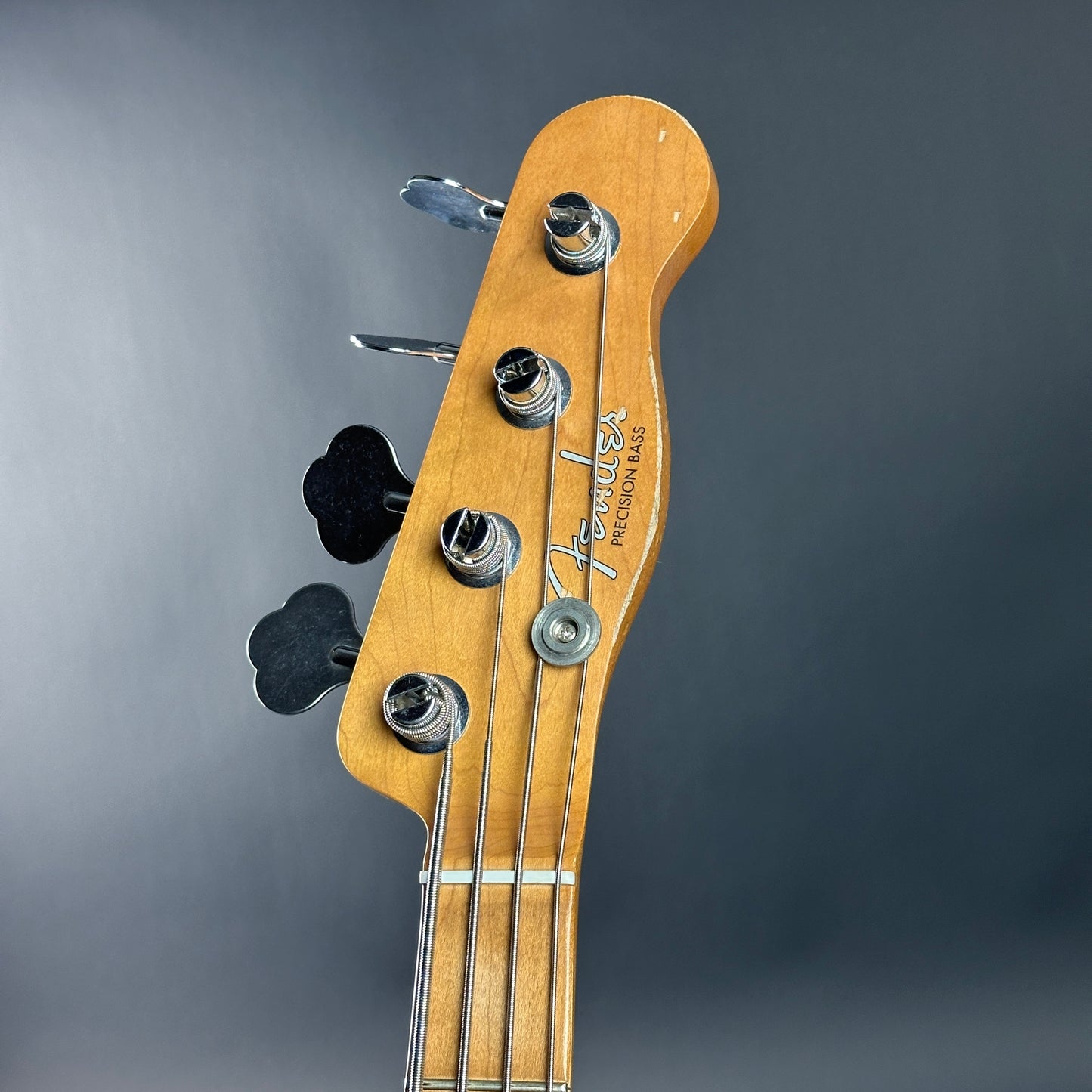Fender bass guitar headstock on a gray background