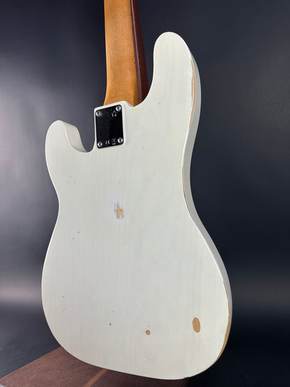 White electric guitar body with visible brand logo on a dark background